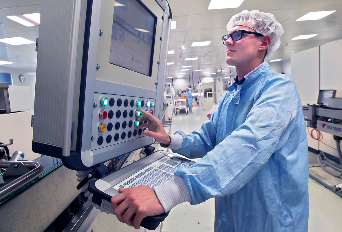 Novoplast Schlauchtechnik nimmt neue Reinräume in Betrieb Masterflex Group, Novoplast: Neue Produktionsanlage mit Bedienpanel im neu errichteten Reinraum von Novoplast in Halberstadt, mit einem Mitarbeiter aus dem Bereich Medizintechnik der die Maschine bedient